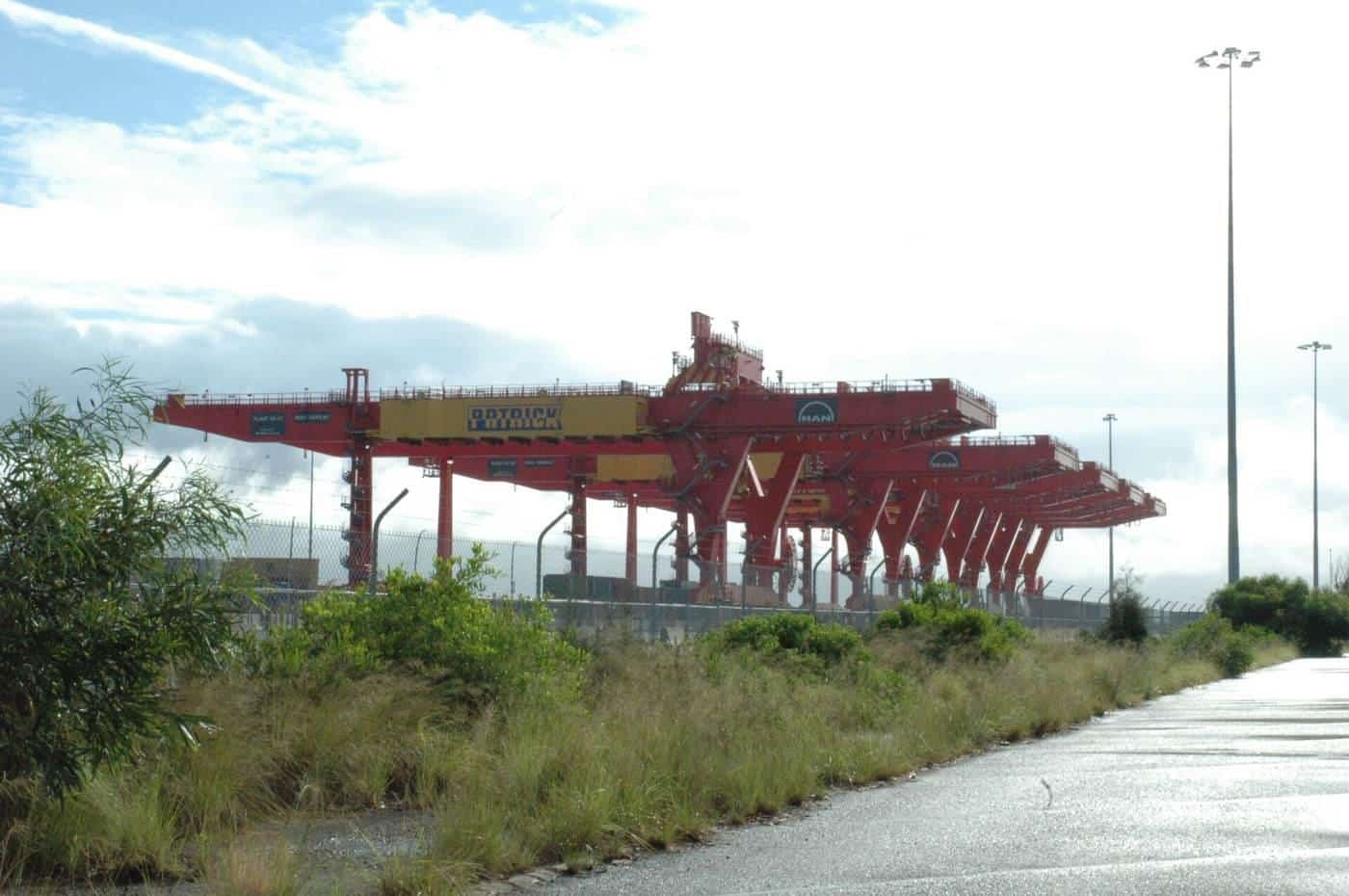 A large container crane loading shipping containers at Port Botany in Sydney